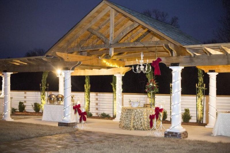 A pergola with a table underneath it decorated for christmas