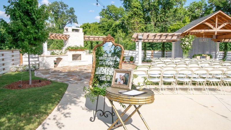 A table with a picture of a bride and groom on it is sitting in front of a row of chairs.