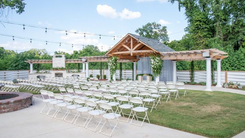 A row of folding chairs are lined up in front of a building.