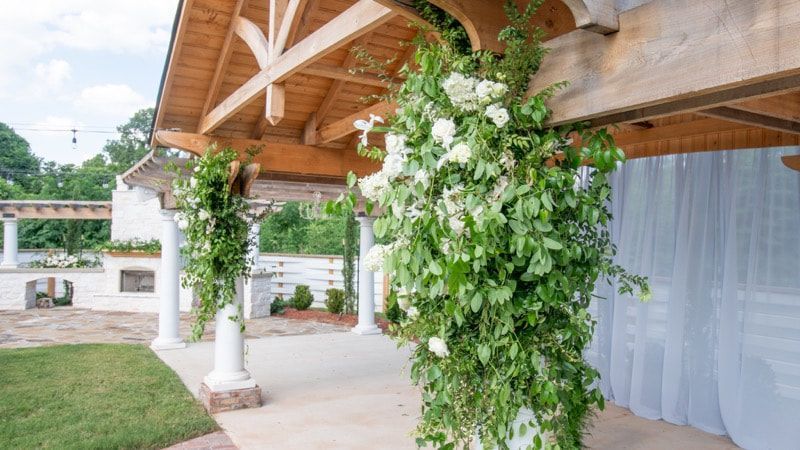 A wooden structure with white flowers growing on it.