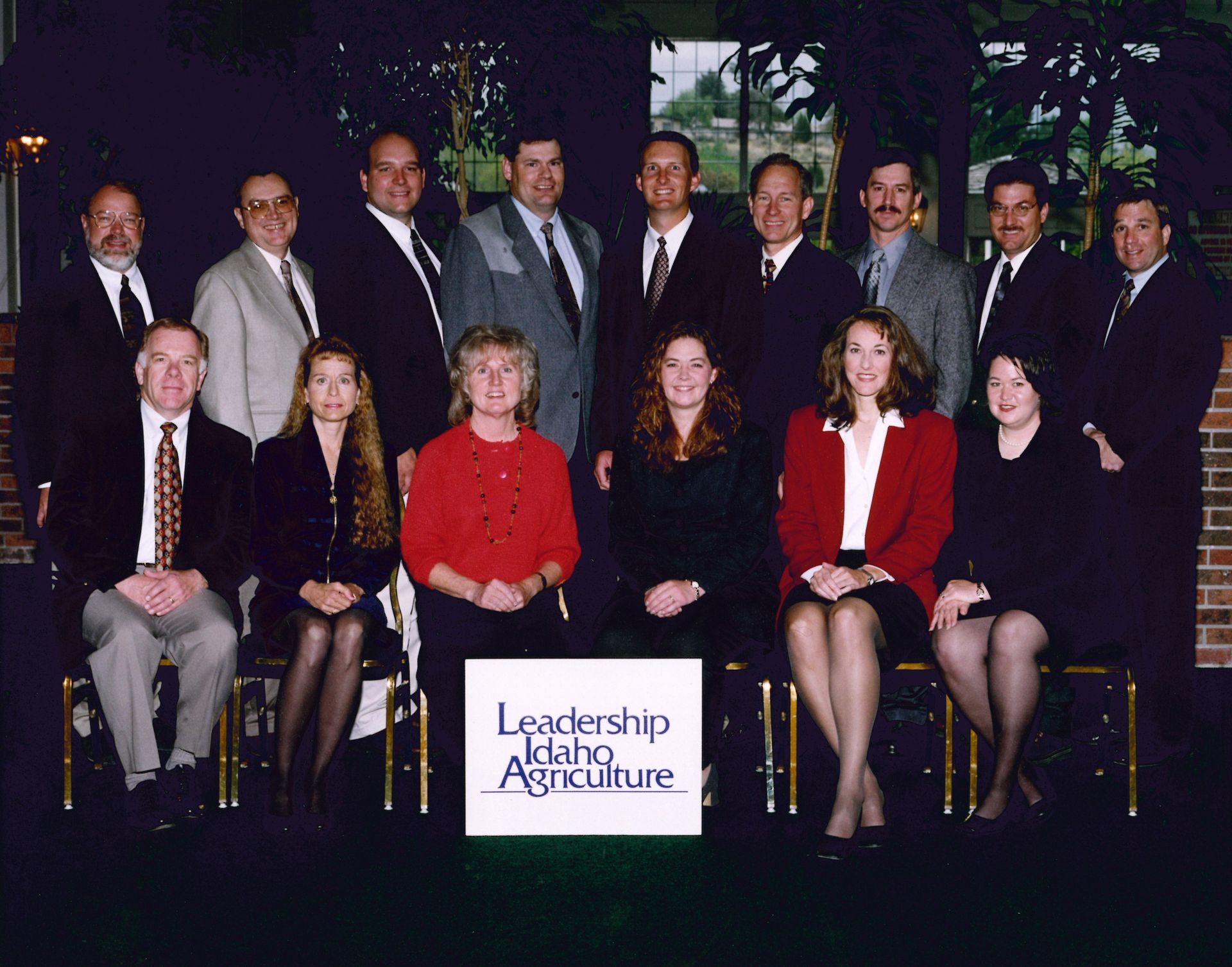 A group posing for a Leadership Idaho Agriculture portrait in front of a banner held by individuals in the front row.