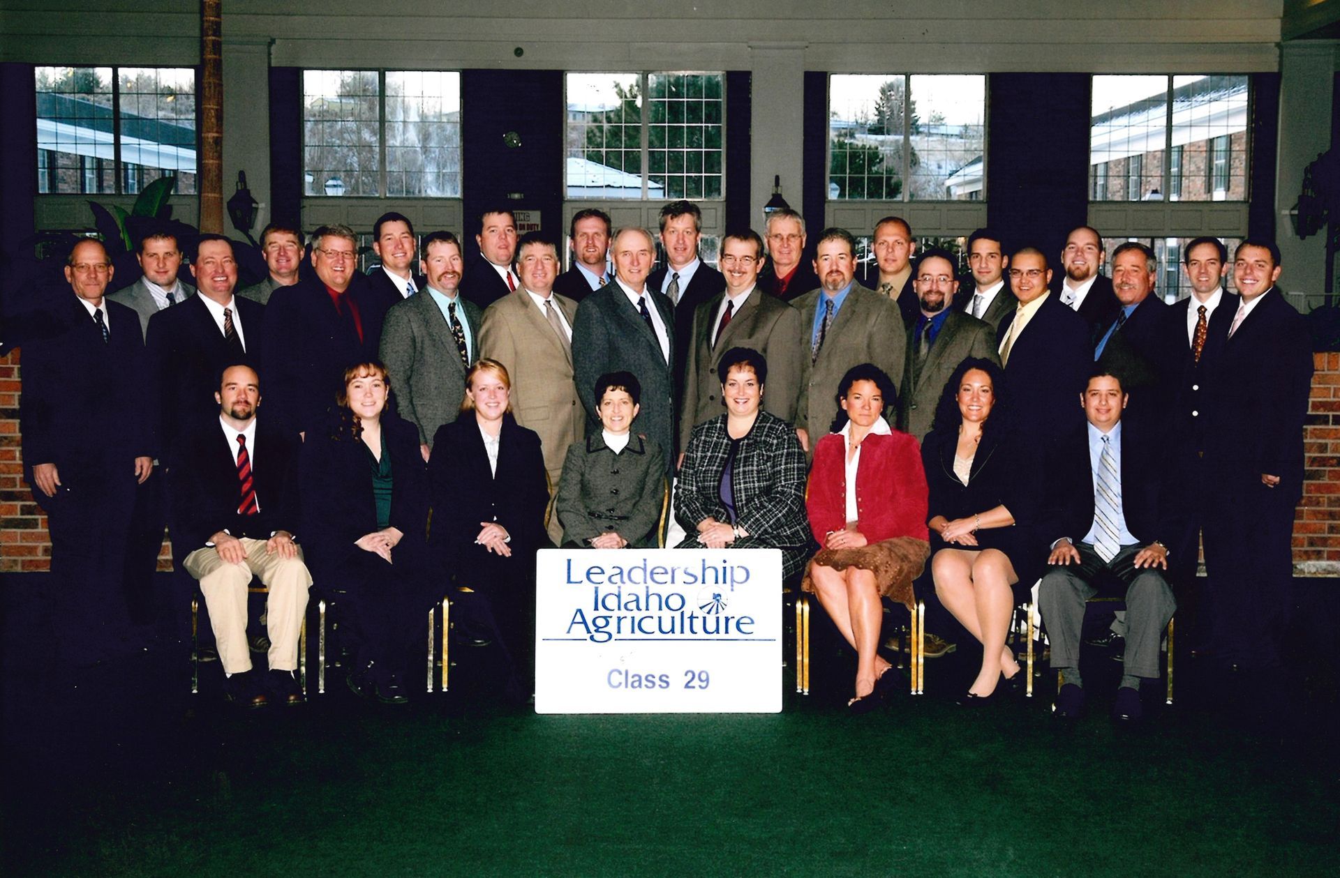 A group of people pose for a photo behind a sign that reads