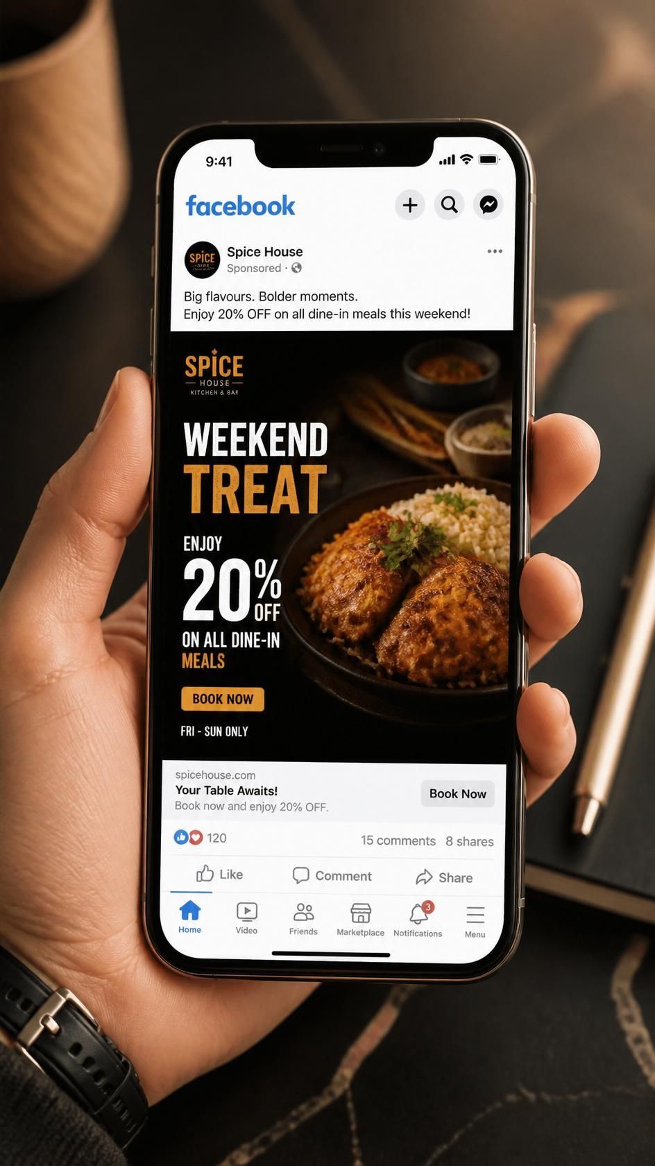 Hand holding a smartphone showing Facebook with a food ad for spicy weekend treats and 20% off
