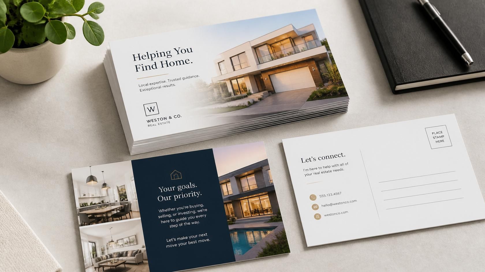 Modern real estate brochure and business cards on a desk, featuring a house photo and navy-and-white design