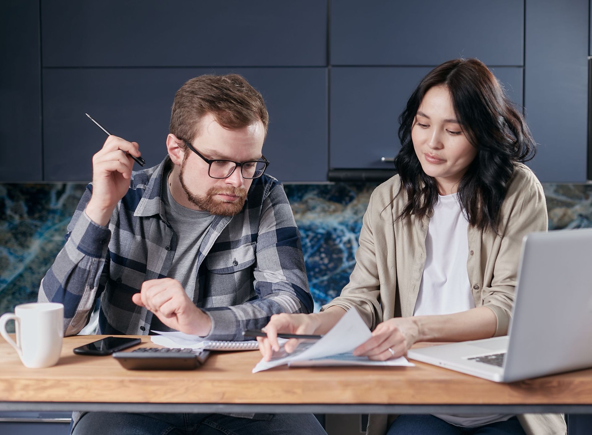 Homeowners planning a remodel budget at their kitchen table