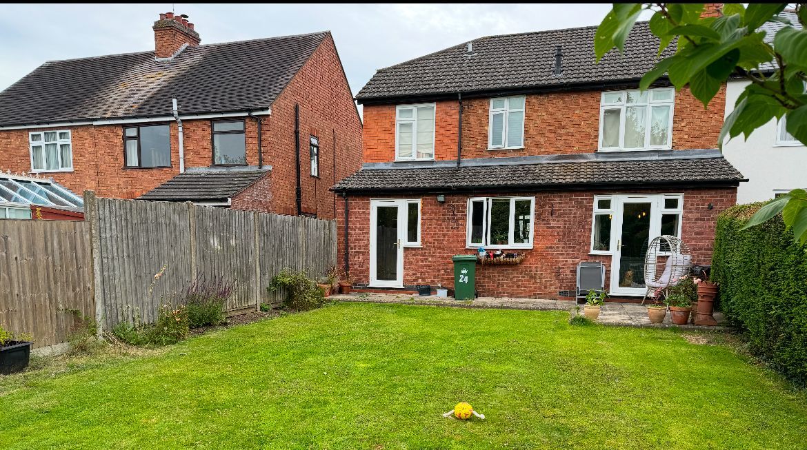 A small house with a red roof is for sale.