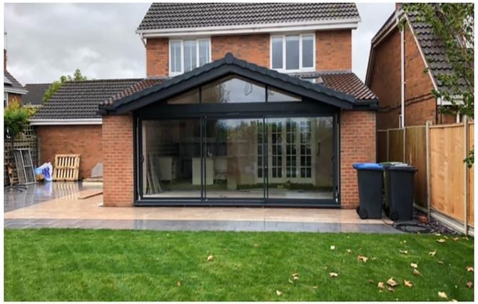 A brick house with a large sliding glass door in the backyard.