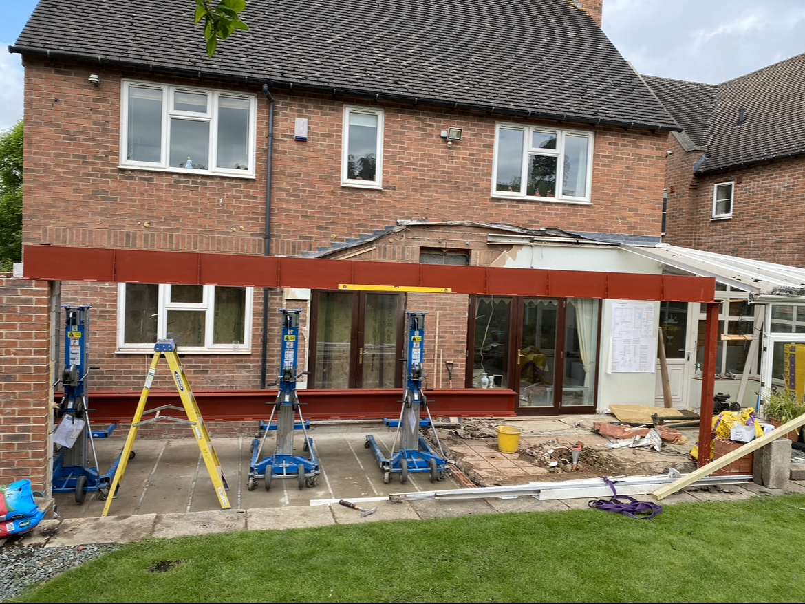 A brick house is being remodeled and a patio is being built.