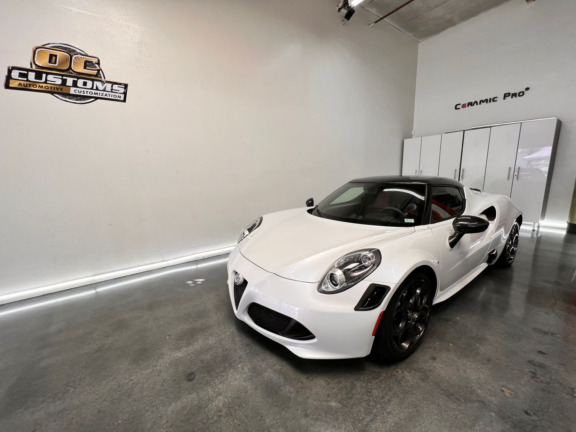 A white sports car is parked in a garage.