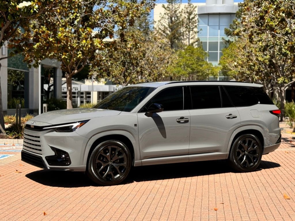 A white suv is parked on a brick sidewalk in front of a building.