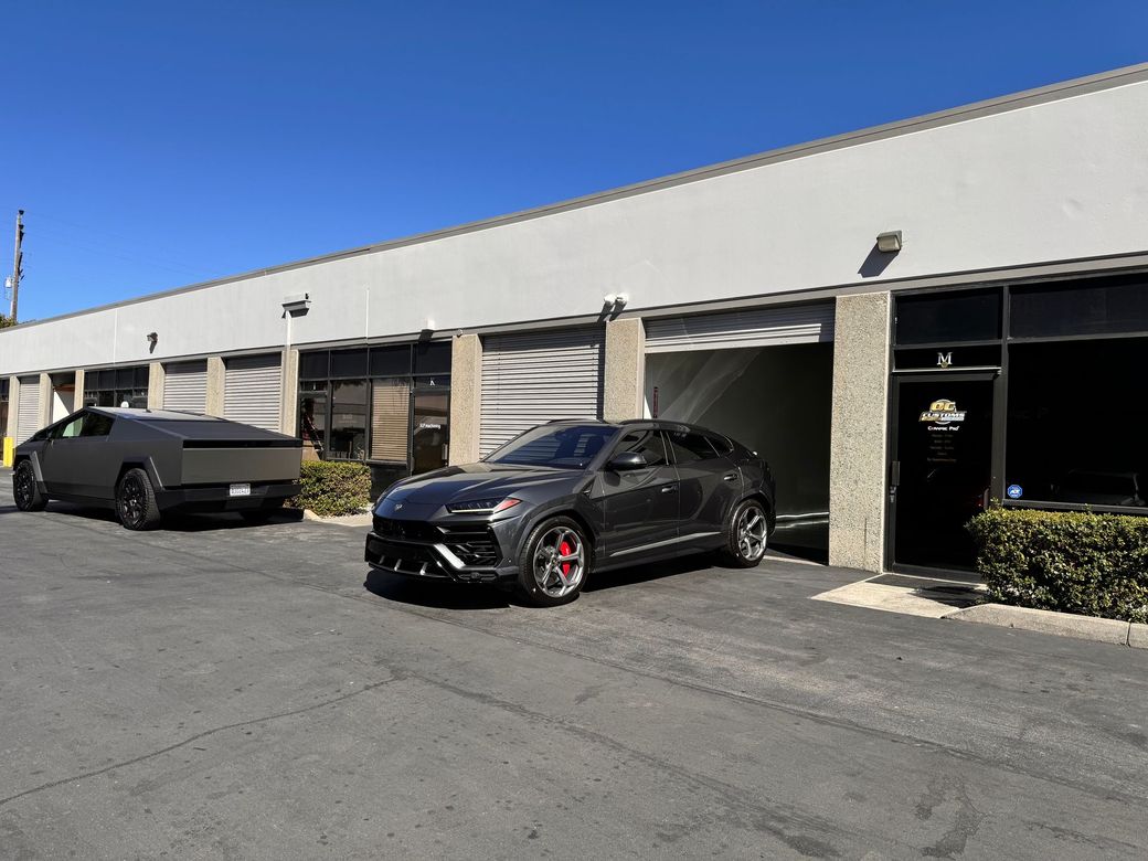 Two cars are parked in front of a building.