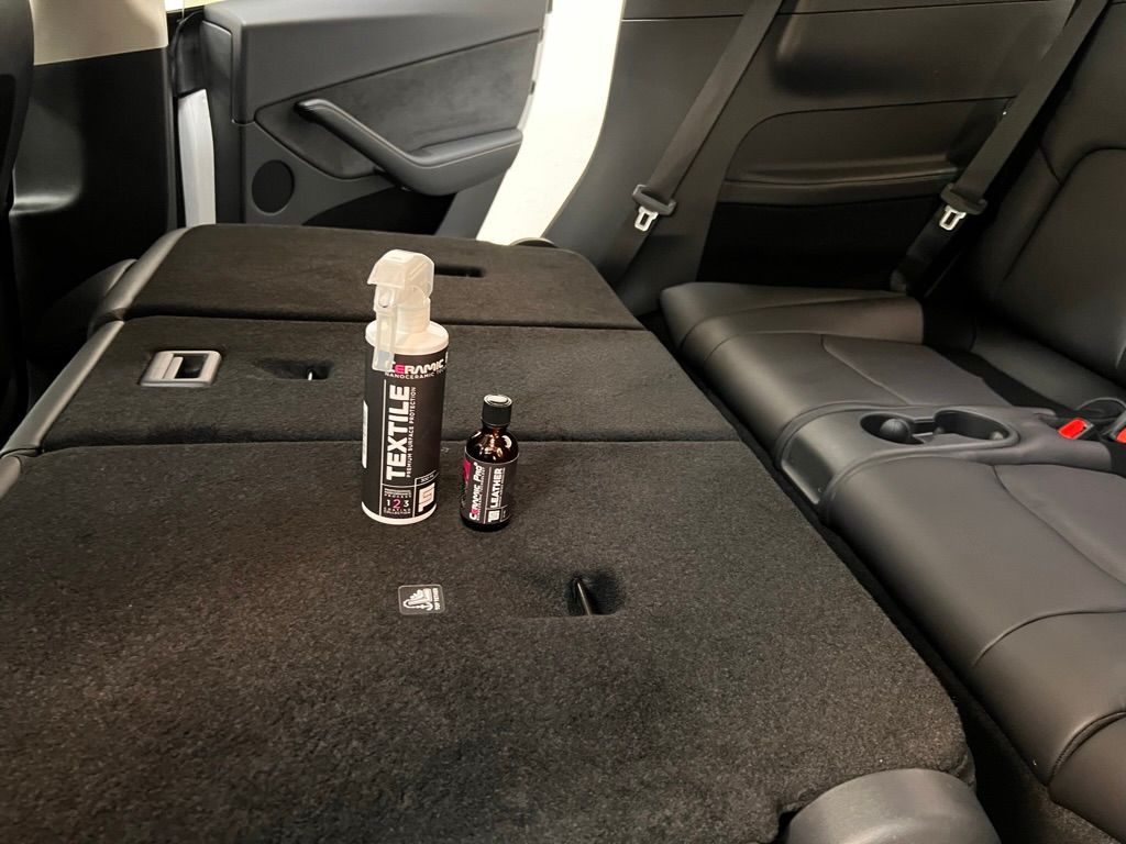 The back seat of a car with a bottle of nestile on the floor