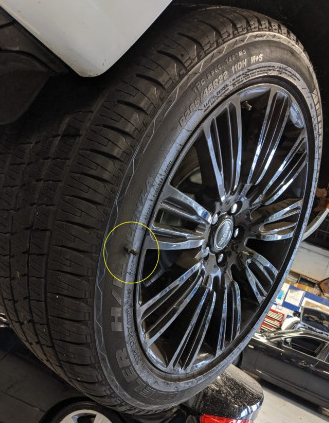 A close up of a tire on a car with a yellow circle around it.