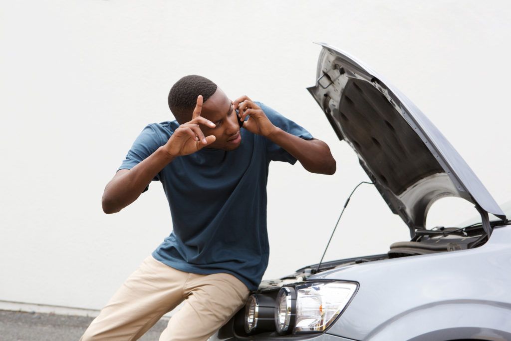 young-guy-calls-for-help-with-by-broken-down-car-PZ2YCH9-1024x683.jpg