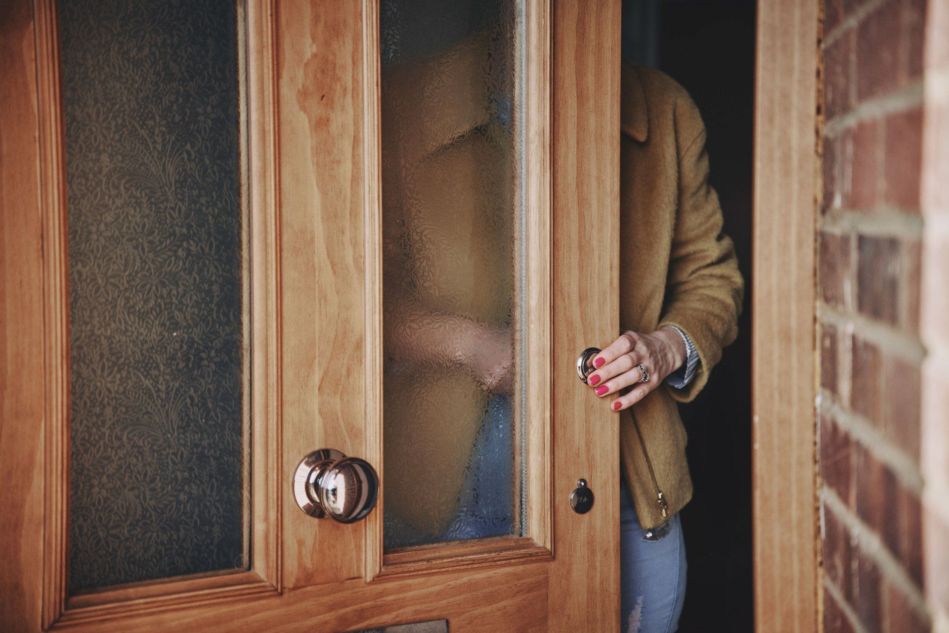 A person is standing in a doorway holding a key.