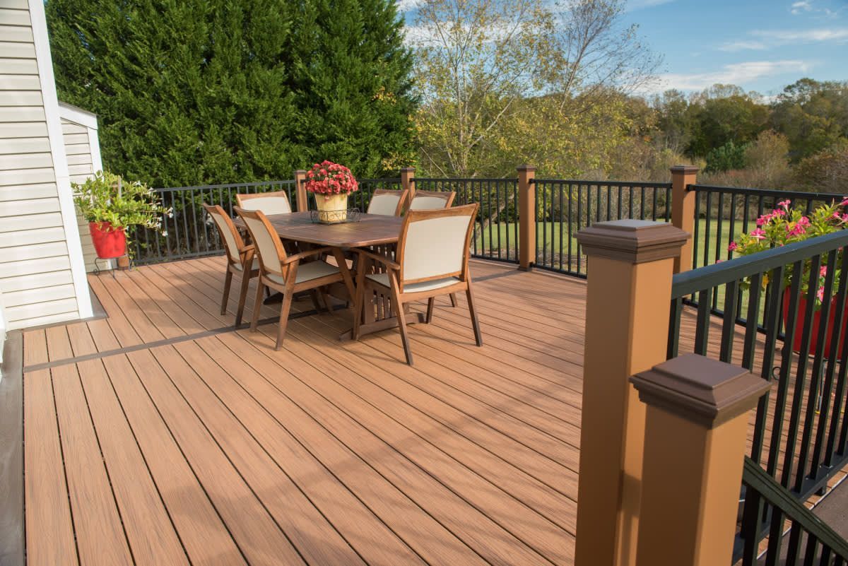 A wooden deck with a table and chairs on it.