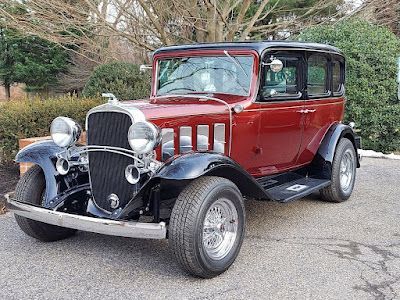 Red and black vintage car with chrome accents parked outdoors. | Dave Muller Automotive & Trailer