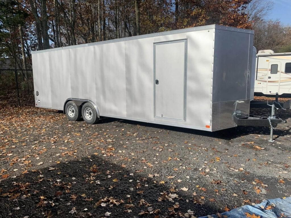 Silver enclosed trailer parked outdoors on gravel. | Dave Muller Automotive & Trailer