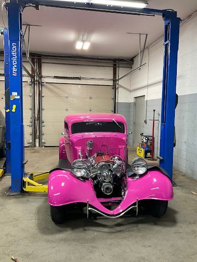 Pink hot rod car on a lift in a garage. | Dave Muller Automotive & Trailer