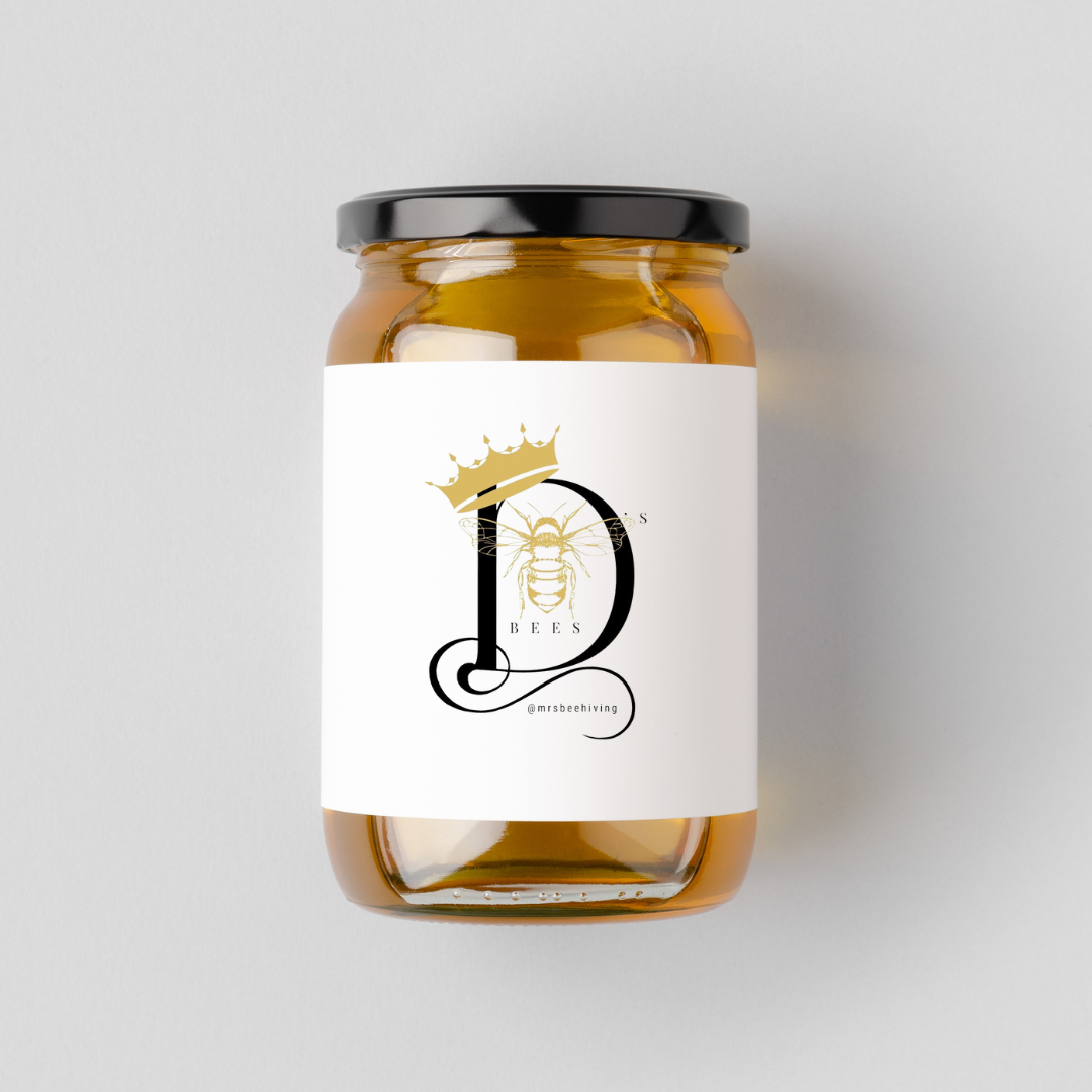 Glass honey pot with a large chunk of natural honeycomb inside.