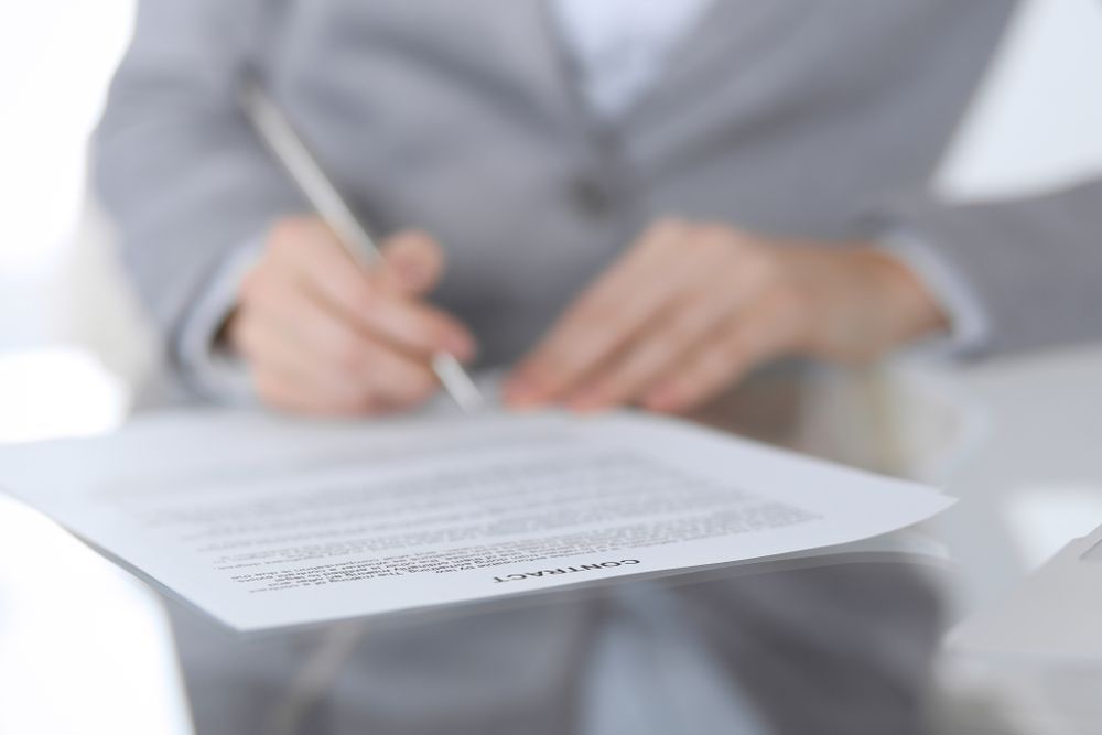 Close-Up of Female Hands With Pen Over Document — Licensed Conveyancing Agent in Fannie Bay, NT