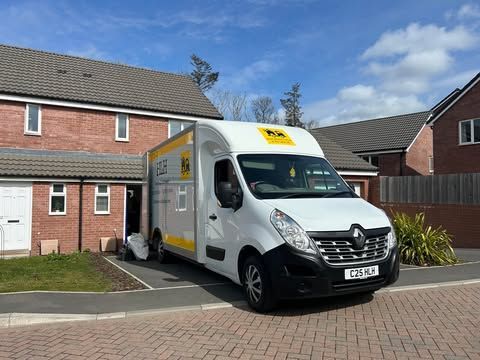 White delivery van parked outside a brick house in a suburban driveway