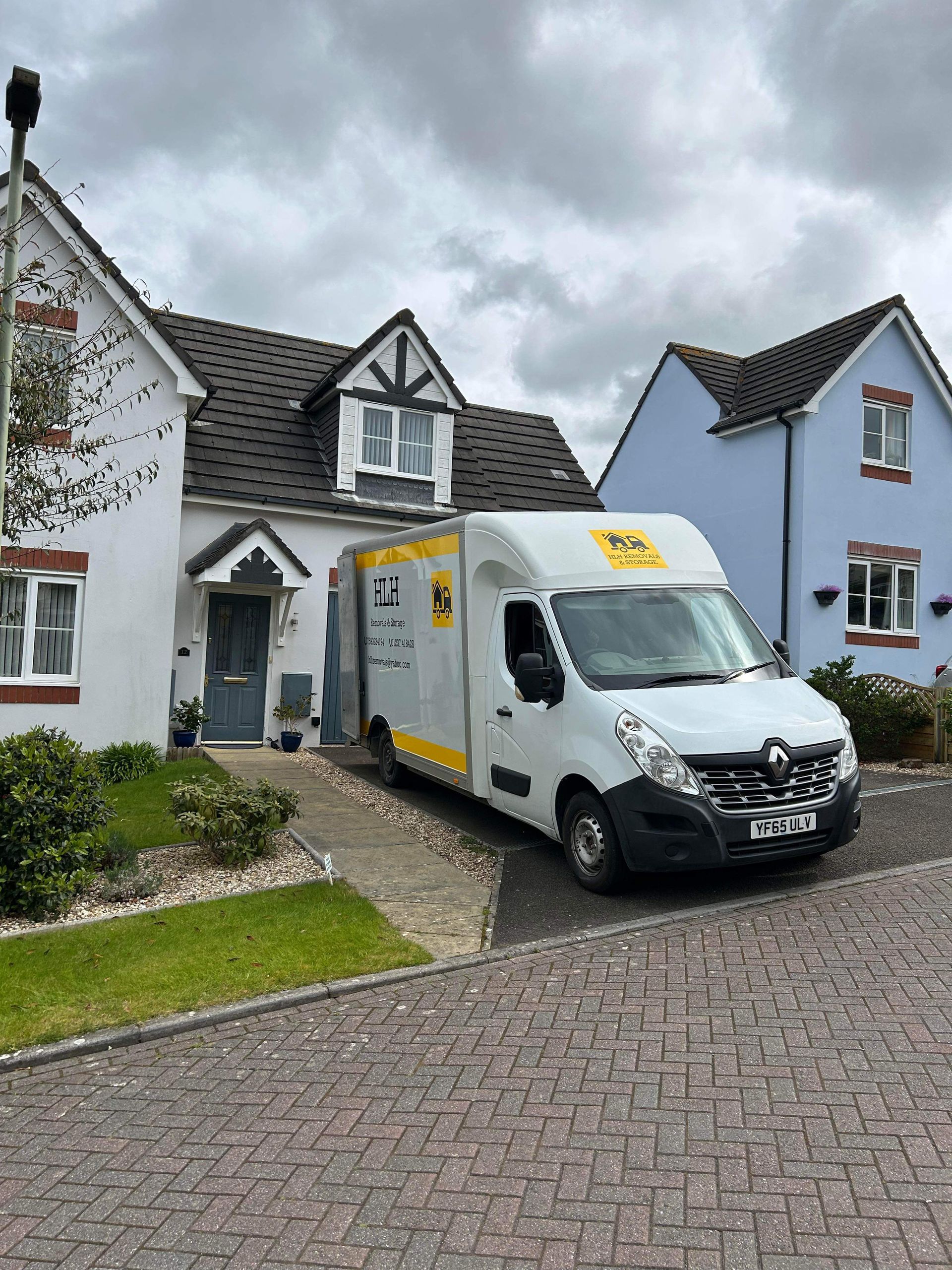 Delivery van parked in front of suburban houses on a cloudy day