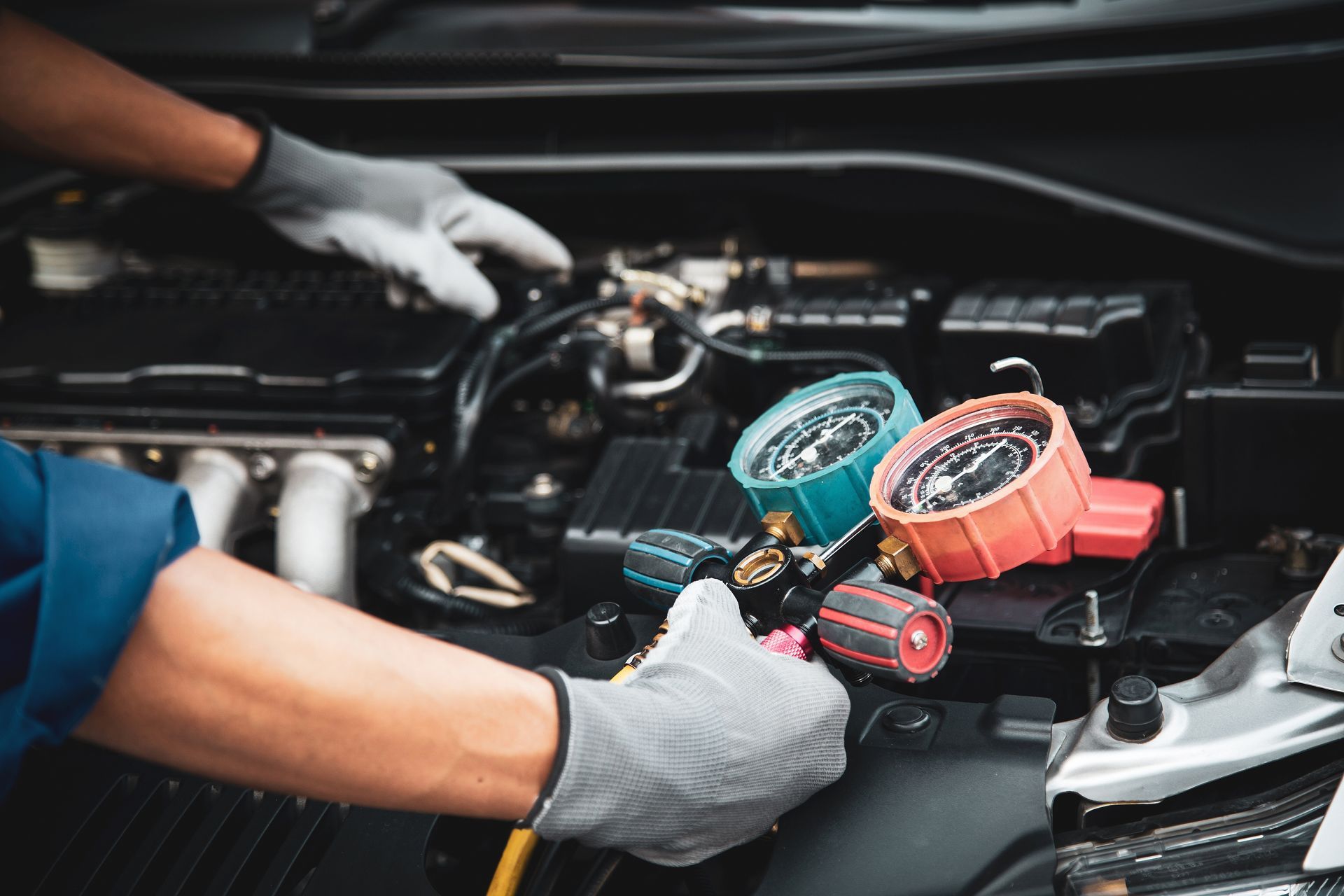 A man is working on the engine of a car.