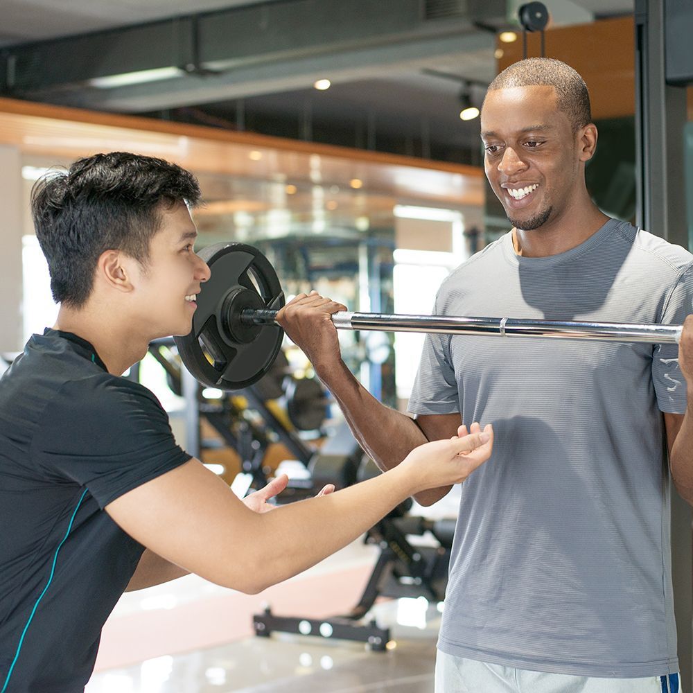 A man and a woman are doing exercises in a gym.