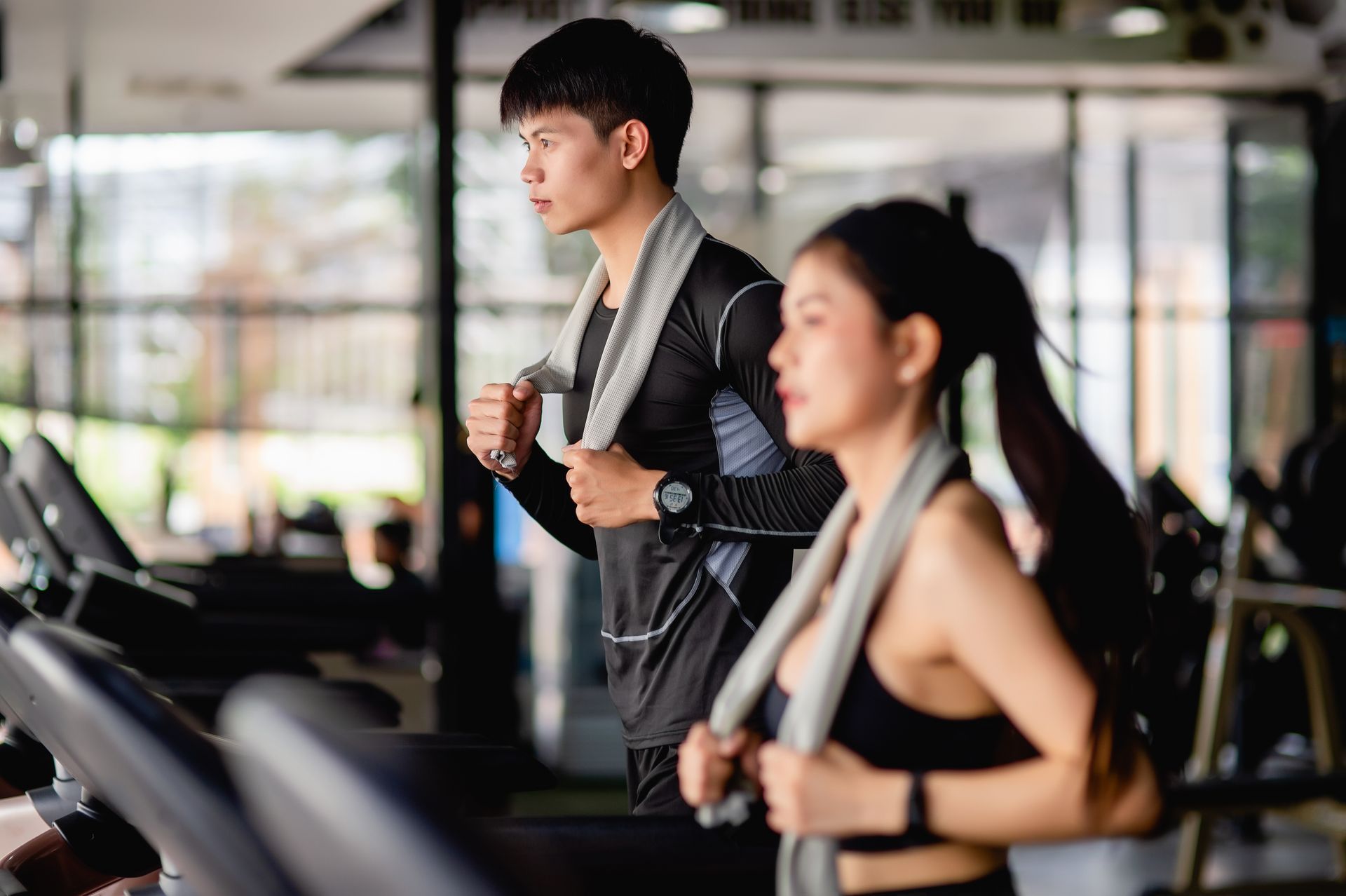 A man and a woman are doing exercises in a gym.