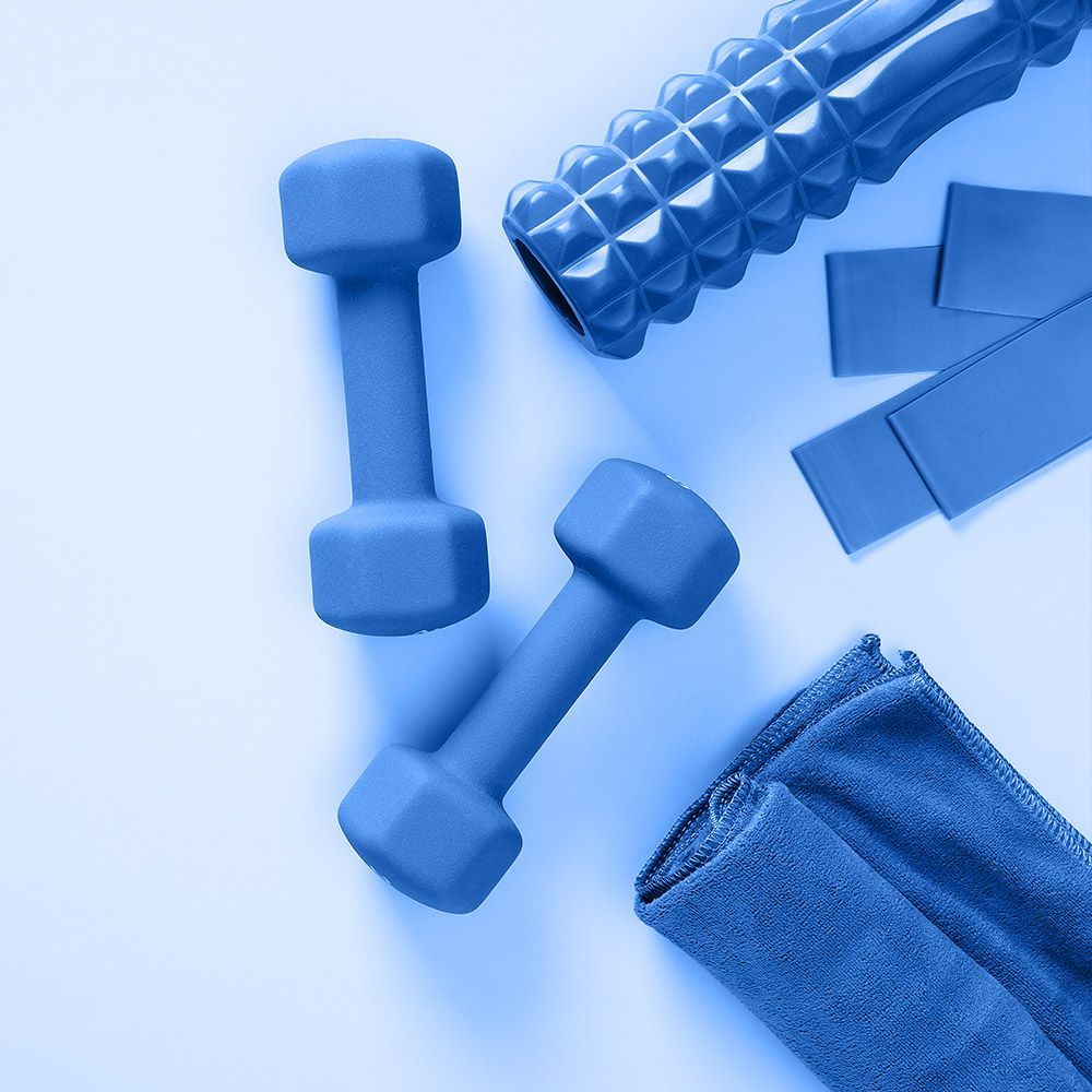 Blue dumbbells , a foam roller , and a towel on a white surface.