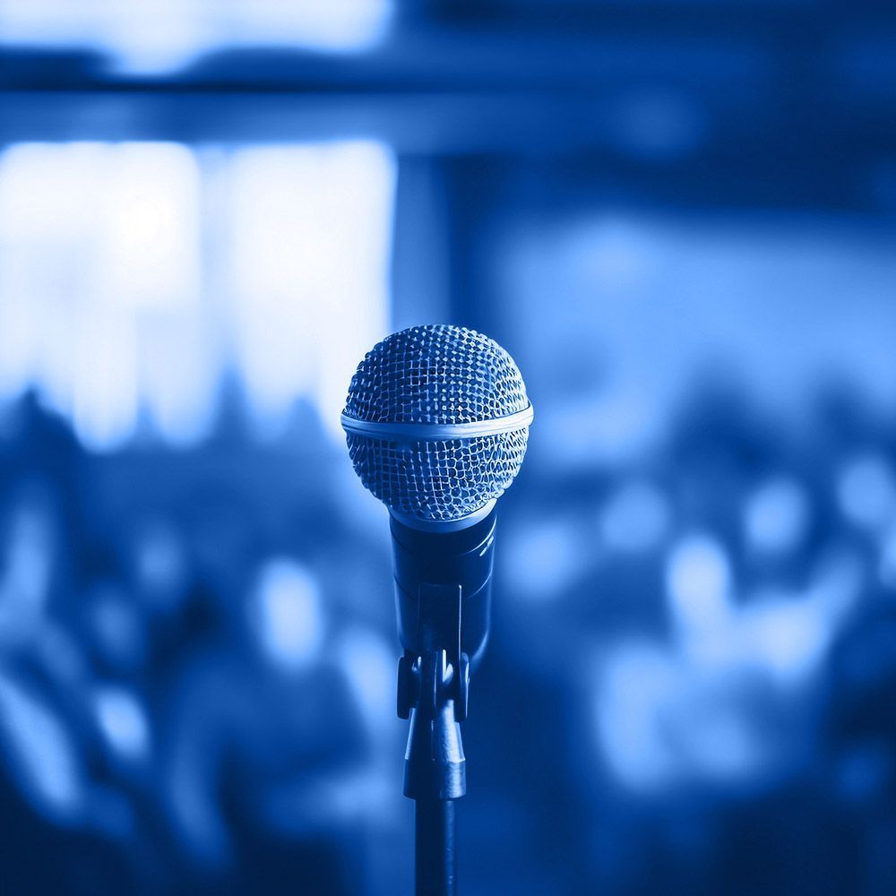 A microphone on a stand with a crowd in the background