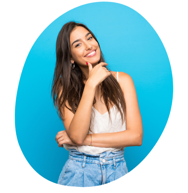 A woman is smiling and holding her hand to her chin.