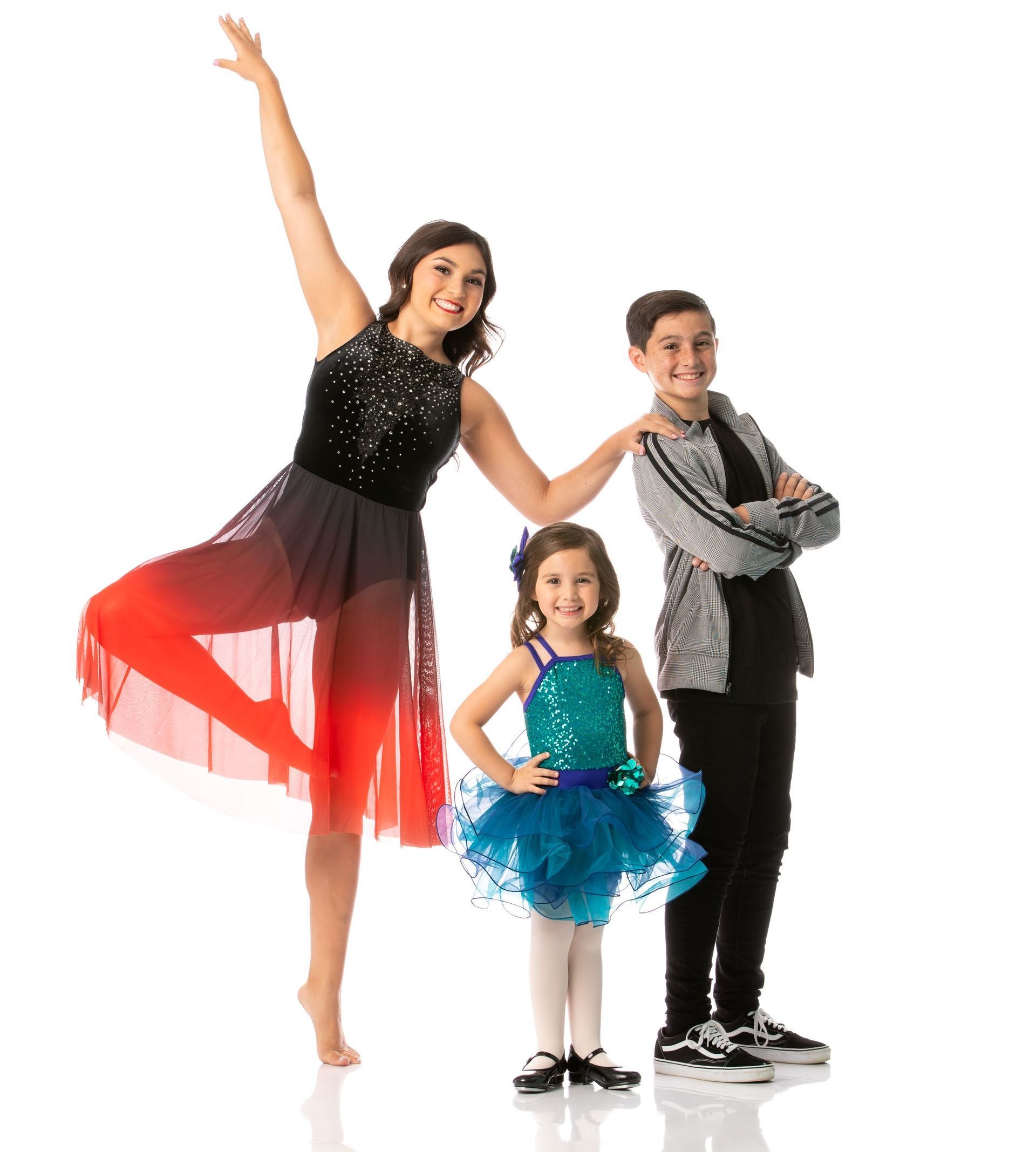 Three dancers posing in colorful costumes against a white background