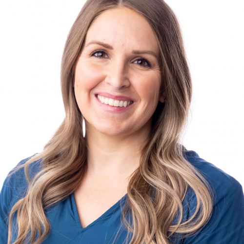 Smiling woman in blue top against a white background
