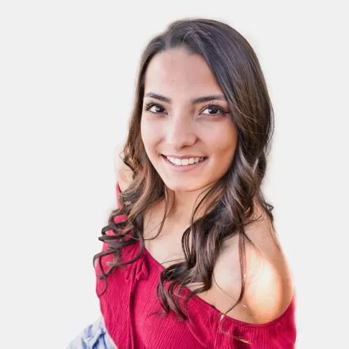 Smiling woman in a pink off-shoulder top against a white background