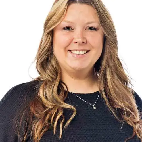 Smiling woman with long wavy blonde hair in a black top on a white background