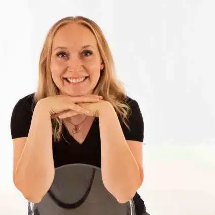 Smiling woman resting her chin on her hands against a white background