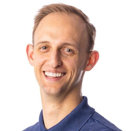 Smiling man in a blue polo shirt against a white background