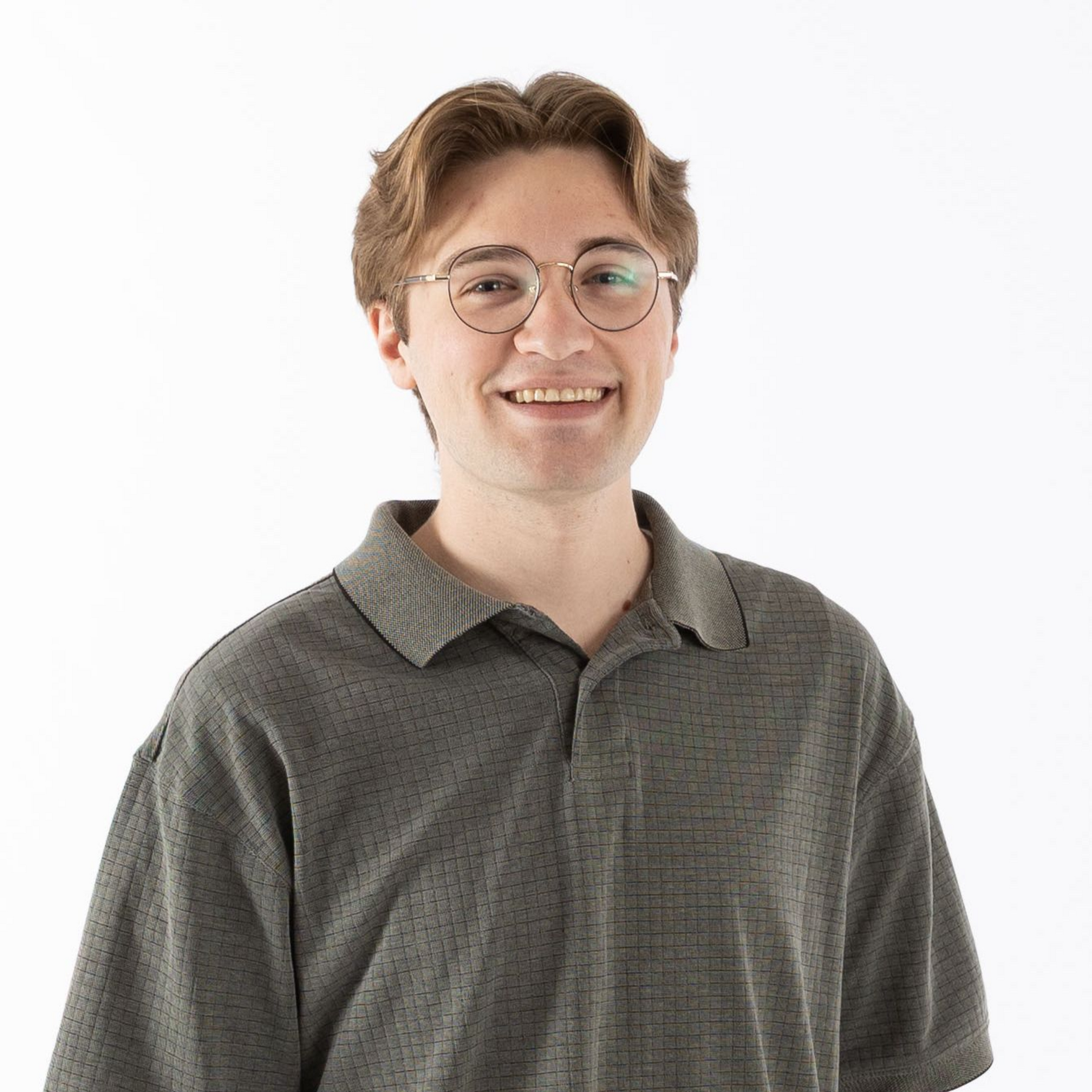 Smiling person with glasses wearing a gray polo shirt against a white background