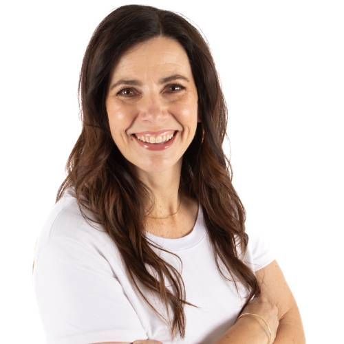 Smiling woman with long dark hair in a white shirt against a white background