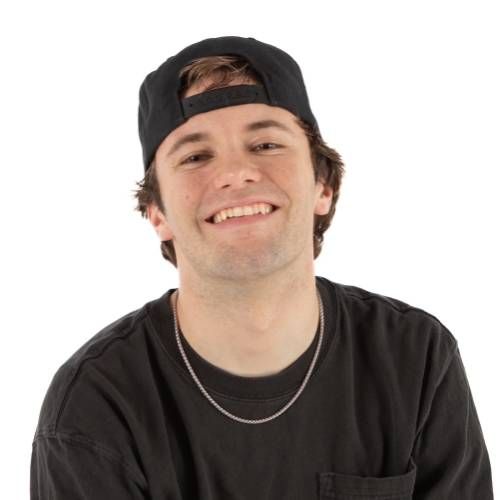 Smiling person in a black shirt and backward black cap on a white background