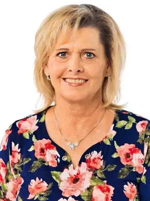 Portrait of a smiling woman in a navy floral blouse on a white background