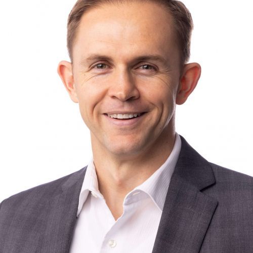 Smiling man in a gray suit and white shirt on a white background