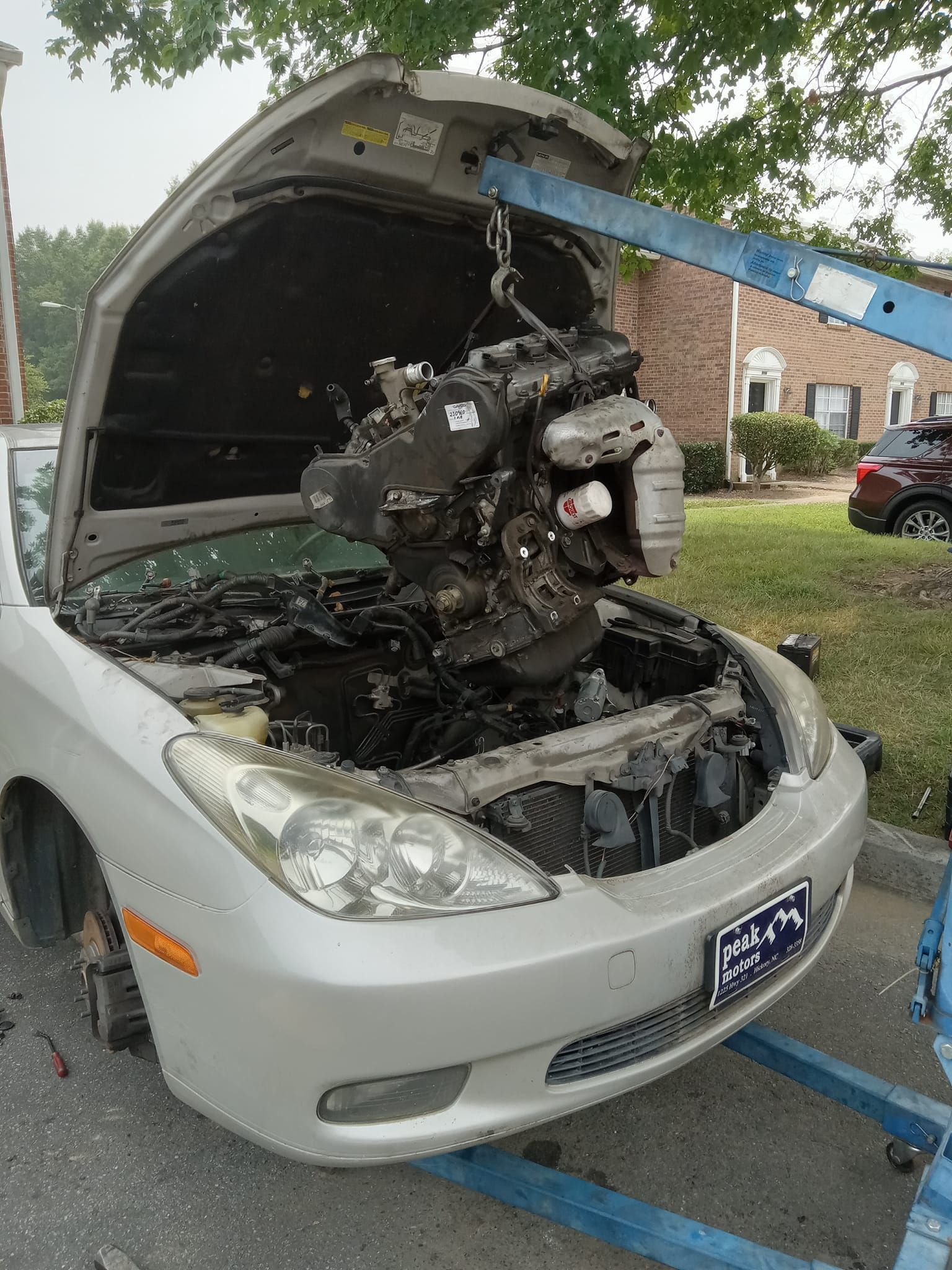 A person is writing on a clipboard in front of a house.