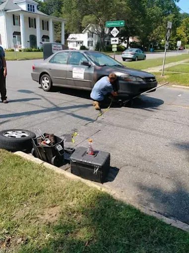 A large house with two garages and a blue door is sitting on top of a lush green lawn.