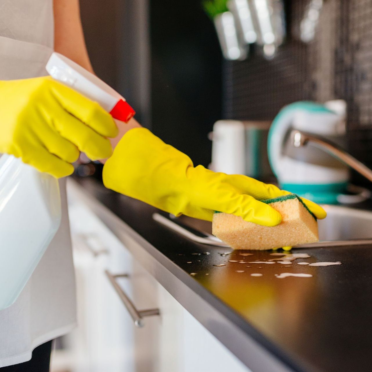 maid cleaning kitchen sink