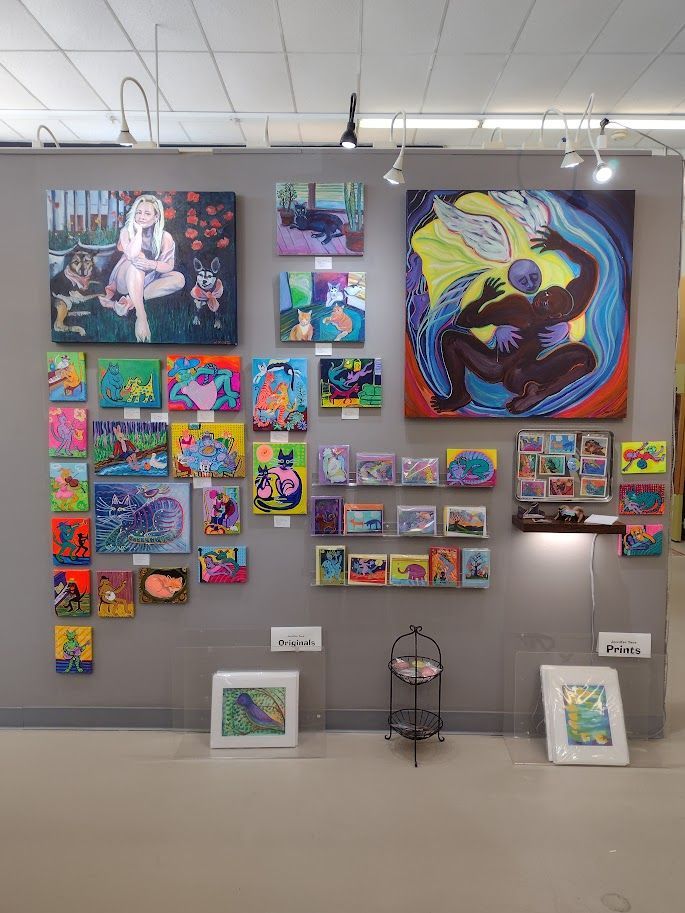 Art gallery wall featuring colorful paintings. Includes portraits and abstract pieces in various sizes.