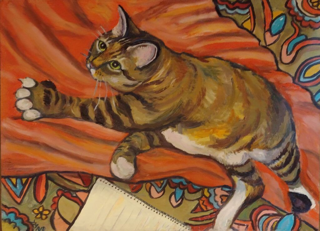 Tabby cat reaching towards a notebook on orange patterned bedding.