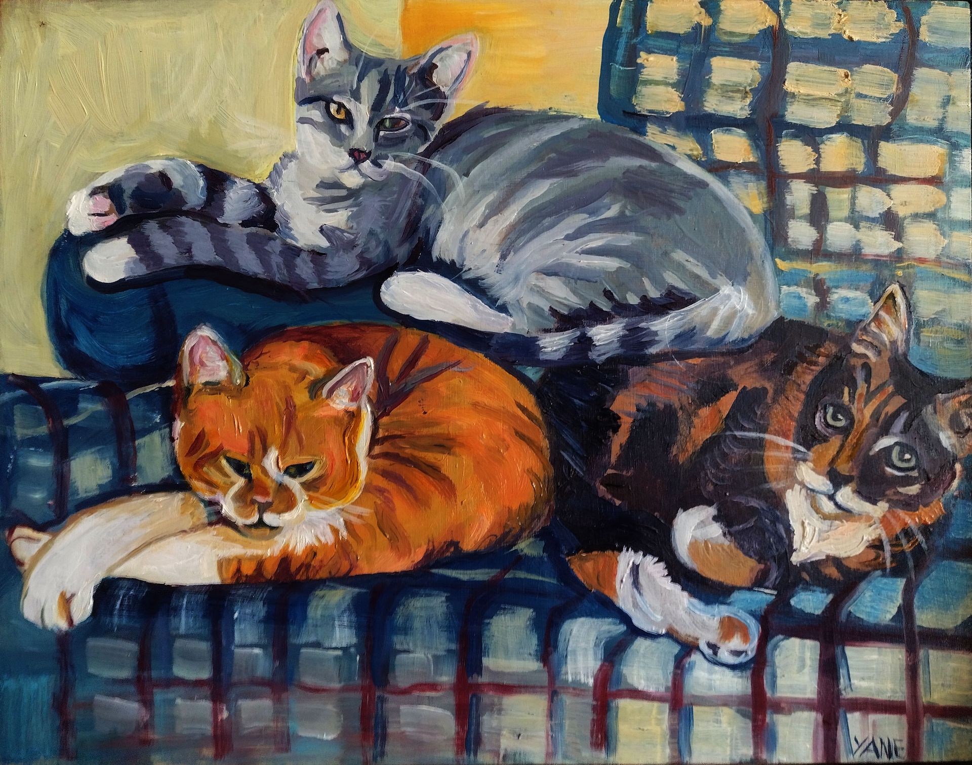 Four cats of various colors resting on a blue plaid couch.